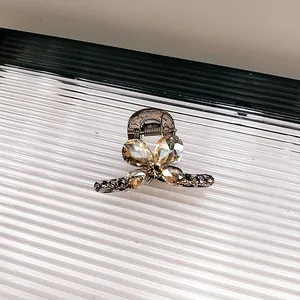 Détail d'une pince à cheveux papillon ornée de cristaux champagne et de strass brillants