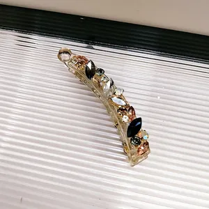 Detailaufnahme der Bananen-Haarklammer mit bunten Kristallen und glänzenden Strasssteinen