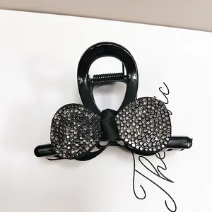 Detail der funkelnden Strasssteine auf schwarzer Haarklammer mit eleganter Schleife