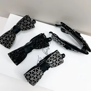 Vue détaillée de pinces à cheveux banane noires avec strass scintillants et nœuds en soie