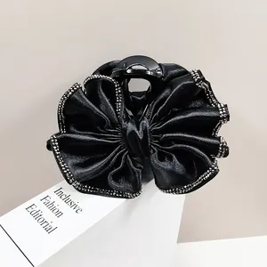 Pince à cheveux élégante avec nœud en satin noir et bordures en strass scintillants
