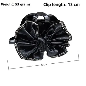 Détail de la pince à cheveux noeud satin noir 13cm avec strass et poids de 53g