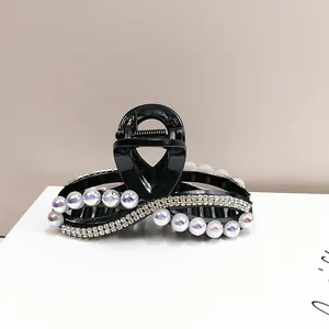 Dettaglio molletta per capelli nera con perle raffinate e strass brillanti di lusso