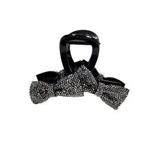 Elegant black claw clip with glittering rhinestone bows for women's hair styling