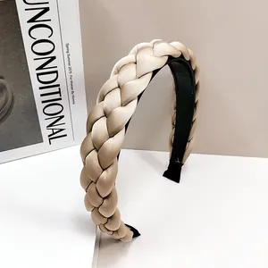 Détail macro du serre-tête tressé en satin champagne avec intérieur antidérapant noir