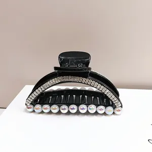 Dettaglio della grande molletta per capelli nera con doppia fila di strass e perle