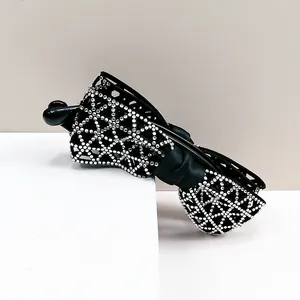 Détails de strass et ruban noir sur une pince à cheveux banane élégante et chic