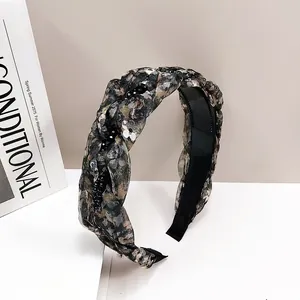 Close-up of floral braided headband with black sequins and comfort padding detail