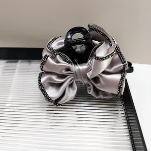 Pince à cheveux élégante avec grand nœud en soie noire et bordure en strass pour femme