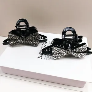 Detailed view of sparkling rhinestones on black bow hair claw clips for women