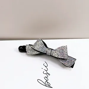 Détail de la pince banane en forme de nœud avec des strass irisés scintillants