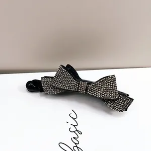 Détail de la pince banane avec nœud en strass argenté et cristaux pour cheveux