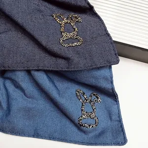 Dettaglio di elastici in denim con decorazioni a testa di coniglio in paillettes lucide
