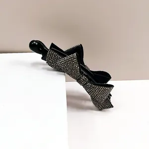 Détail d'une pince banane de luxe avec des strass argentés étincelants et motif de nœud