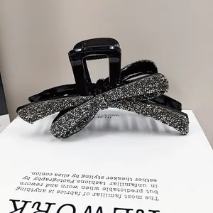 Elegante pinza para el pelo negra con lazo grande y detalles de pedrería plateada
