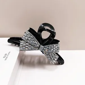 Macro view of the large black bow hair claw clip with shimmering silver rhinestones