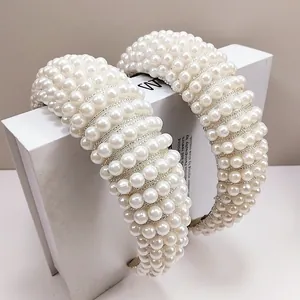 Detail of elegant wide sponge headband with rows of polished white faux pearls