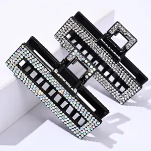 Macro detail of large square hair claws with sparkling rhinestones on black resin