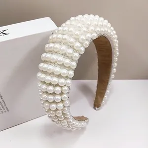 Detail of elegant white pearl headband with padded sponge velvet and artistic prop book