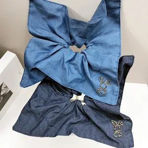 Dettaglio di elastici per capelli in denim blu chiaro e scuro con coniglio di cristallo