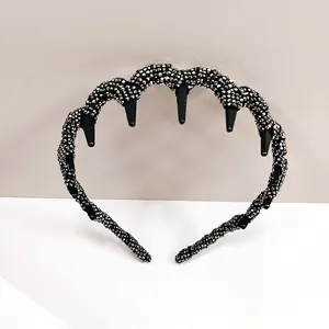 Close-up of black wave headband with sharp spikes and sparkling silver glitter beads
