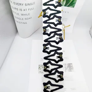 Detail of 10 black fabric star hair clips with colorful rhinestones on display card