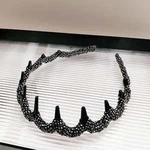 Detail of wavy black headband featuring silver micro-beads and punk style conical spikes