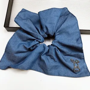 Dettaglio di elastico per capelli in denim con un piccolo coniglio di strass neri