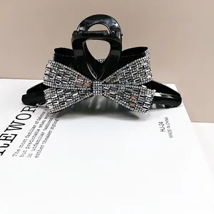 Macro shot of sparkling rhinestones on a black bow hair claw clip for elegant styling