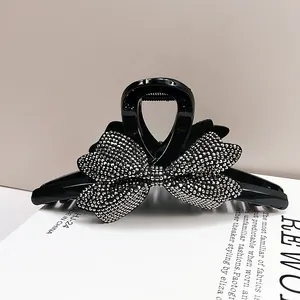 Molla per capelli in acrilico nero con grande fiocco di strass argentati da donna