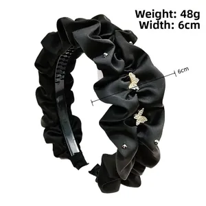 Détail d'un serre-tête en satin noir plissé avec papillons en cristal, 6 cm de large et 48 g