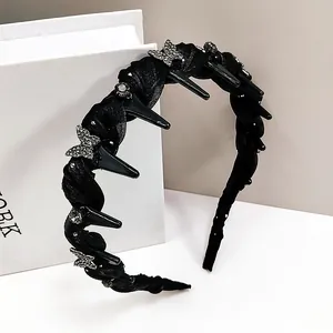 Détails d'un serre-tête en tissu noir orné de papillons argentés et de strass brillants