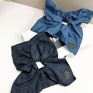 Blue denim fabric scrunchie set with beaded camellia flower charm and elegant texture