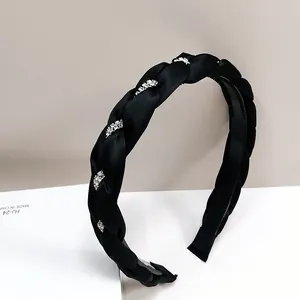 Dettaglio cerchietto trecciato in raso nero con strass luminosi e dentini interni antiscivolo