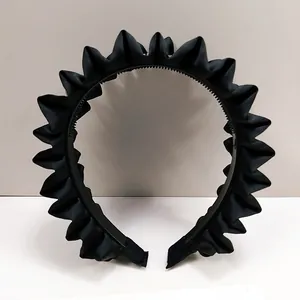 Détail du serre-tête en satin noir plissé montrant les dents antidérapantes