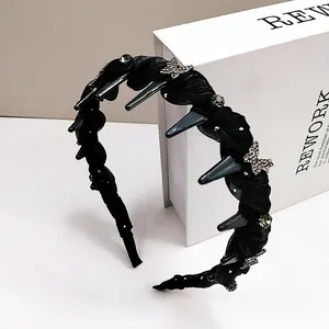 Détail d'un serre-tête tressé noir avec papillon en strass et peigne de fixation interne