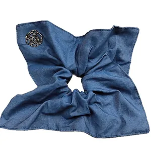 Blue denim texture scrunchie with a black glitter camellia flower on a white background