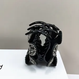 Détail d'une pince à cheveux noire avec strass argentés brillants pour un style élégant