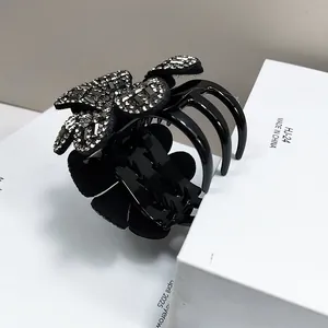 Détail de la pince à cheveux en forme de fleur avec strass brillants et dents serrées