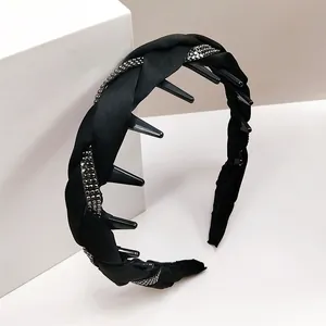 Detalle de diadema negra trenzada con diamantes de imitación y dientes internos