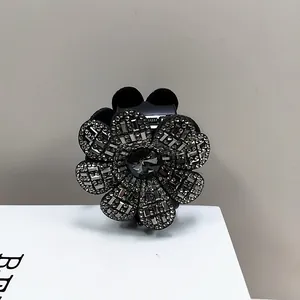 Détail de la pince à cheveux fleur avec strass gris et cristal central brillant