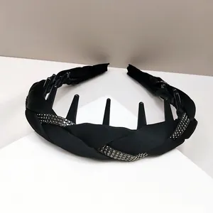 Detalle de diadema trenzada negra con pedrería y dientes internos para sujetar el cabello