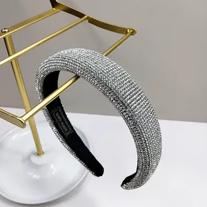 Detailed close-up of a luxury padded headband with shimmering rhinestones and handmade label