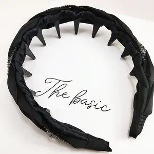 Detalle de diadema de satén negro con pedrería plateada y dientes internos antideslizantes