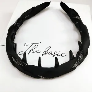 Detalle de diadema de tela negra trenzada con diamantes de imitación y dientes internos