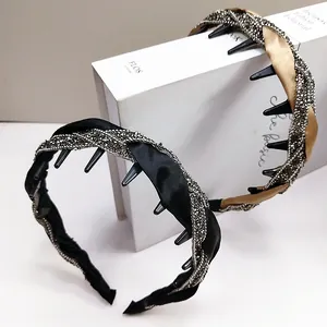 Detail von gedrehten Strass-Haarbändern mit rutschfesten Innenzähnen in Schwarz und Gold