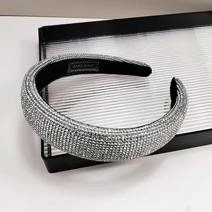 Detailed macro view of silver rhinestone headband with black lining and handmade label