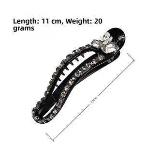 Detail of 11cm black resin hairpin featuring brown rhinestones and white flower motif