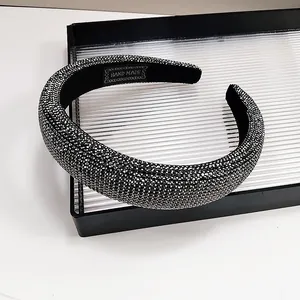 Close-up of luxury padded headband with dark rhinestones and a handmade label