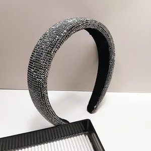Detailopname van een brede haarband met zilveren strass-steentjes en zwarte voering